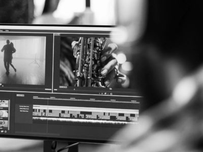 Young freelancer editing footage on software, working to edit video montage with color grading and audio effects. Sound and film production content, making creative movie on computer.